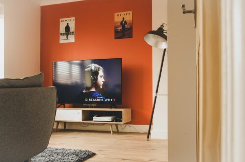 black flat screen tv turned on near white and black torchiere